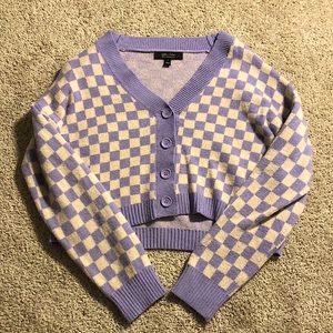White and purple checkered sweater, cropped.
